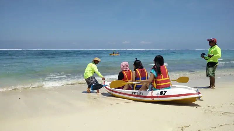 Wisatawan menikmati aktivitas kano di Pantai Pandawa, Bali.